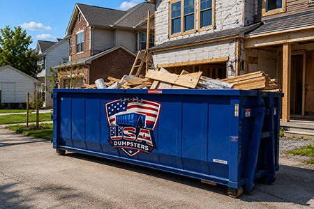 blue dumpster with branding logo infront of a residential neighborhood under construction